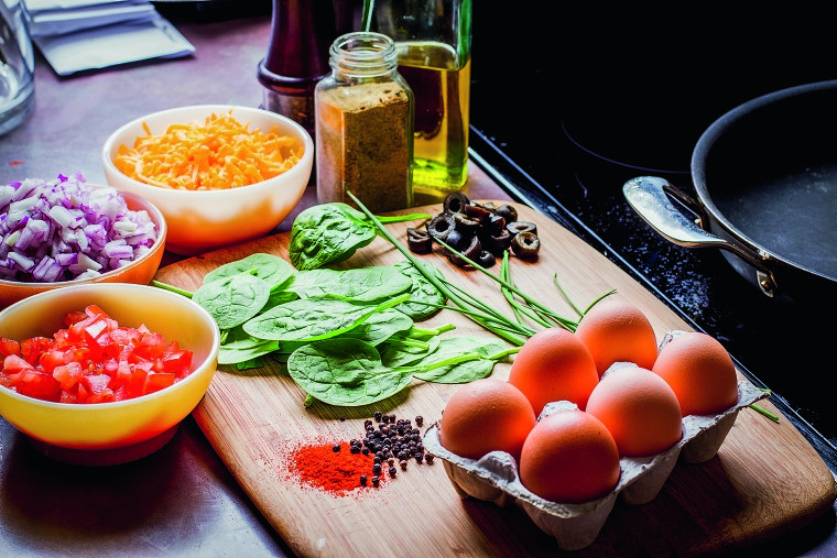 Eier und Gemüse auf Küchenbrett