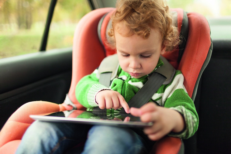 Kleinkind im Auto mit Tablet