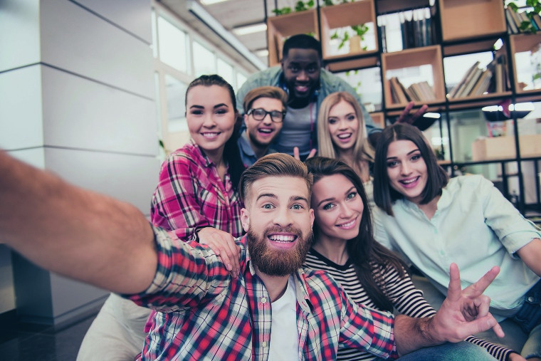 Junge Erwachsene posieren für ein Selfie.