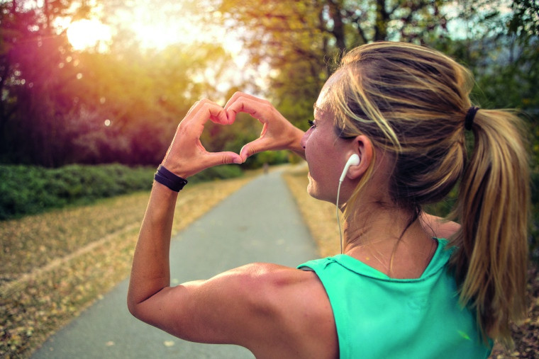 Joggerin formt Herz mit Händen.