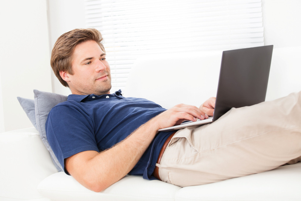 Mann mit Laptop auf dem Sofa Mann mit Laptop auf dem Sofa