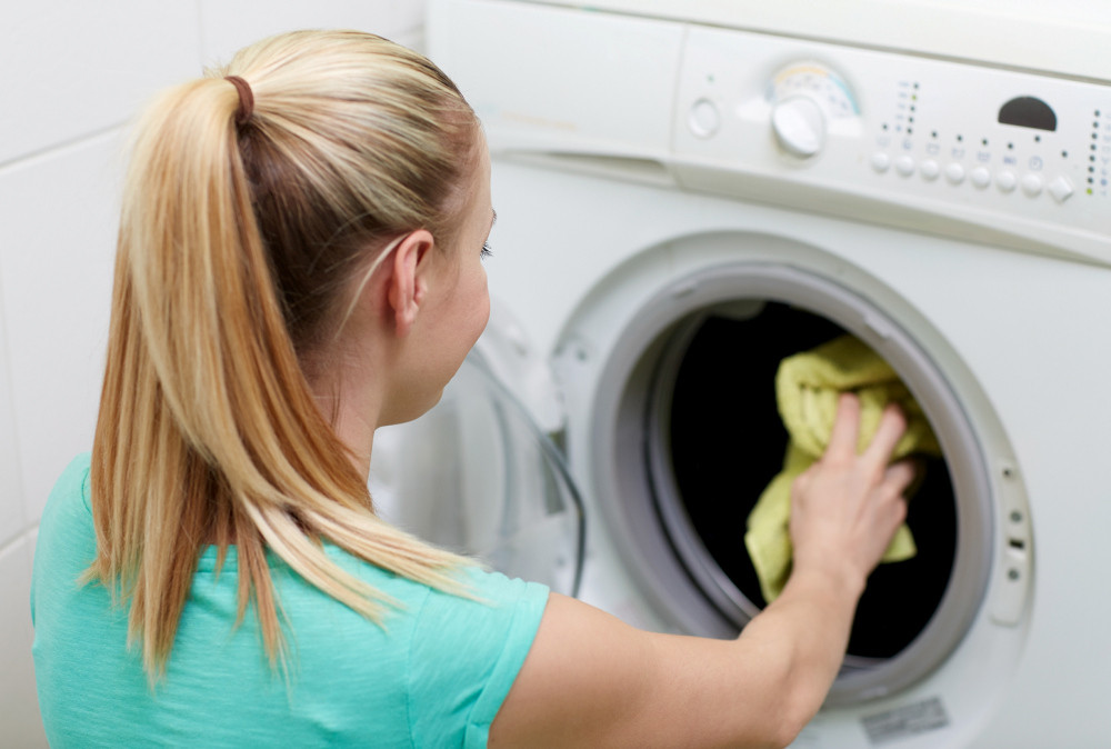 junge PTA wäscht Wäsche in der Waschmaschine