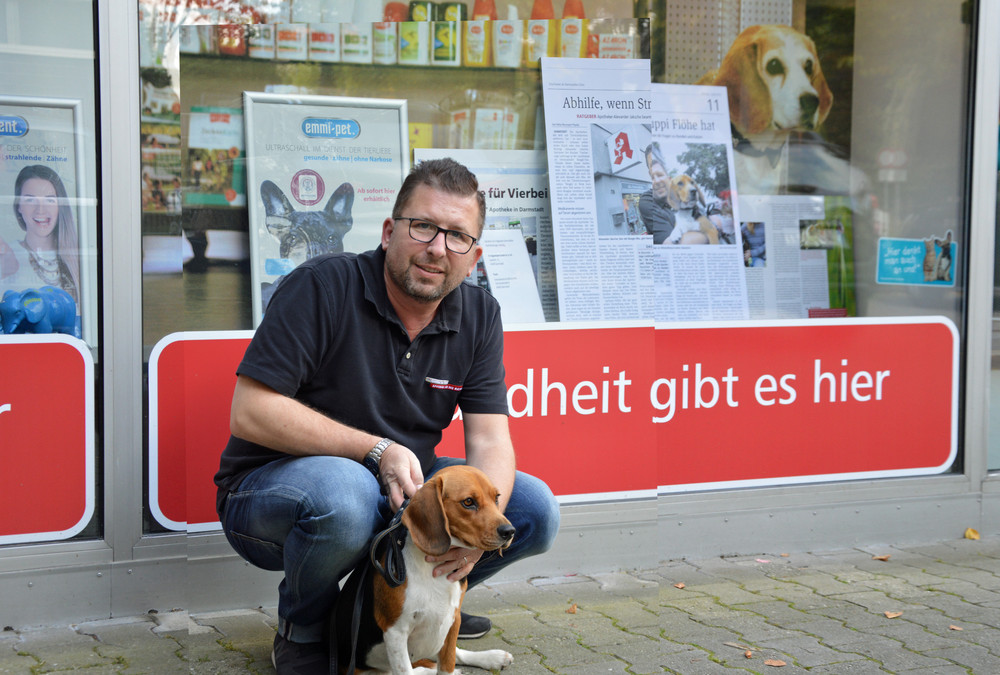 Apotheker Alexander Jaksche mit seinem Beagle vorm Schaufenster.