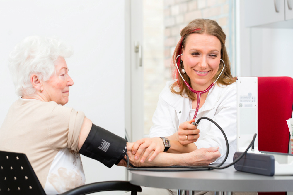 Ärztin misst Seniorin in der Praxis den Blutdruck