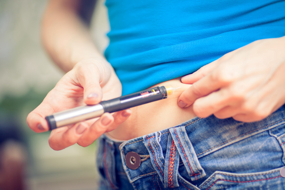 Frau, die sich mit einem Pen Insulin in die Bauchfalte injiziert. Frau, die sich mit einem Pen Insulin in die Bauchfalte injiziert.