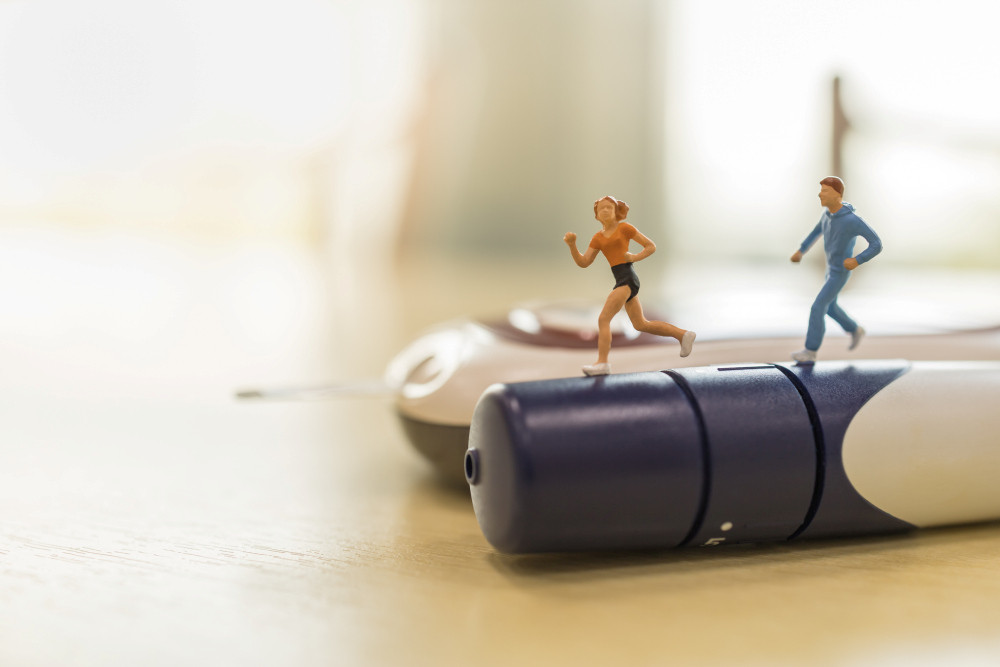 Miniaturfiguren Mann und Frau laufen auf einem Insulinpen