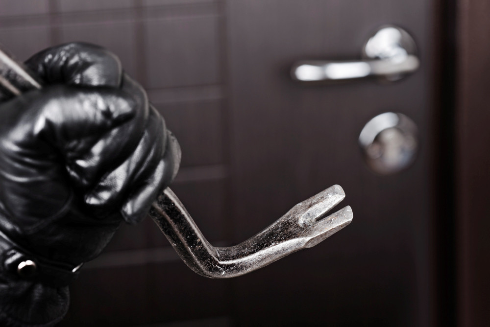 Einbrecherhand mit schwarzem Handschuh hält Brechstange. Einbrecherhand mit schwarzem Handschuh hält Brechstange.