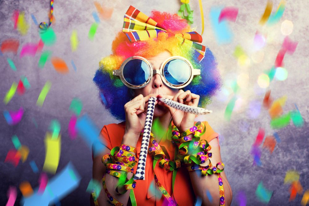 Frau zum Fasching mit Konfetti und Tröte Frau zum Fasching mit Konfetti und Tröte
