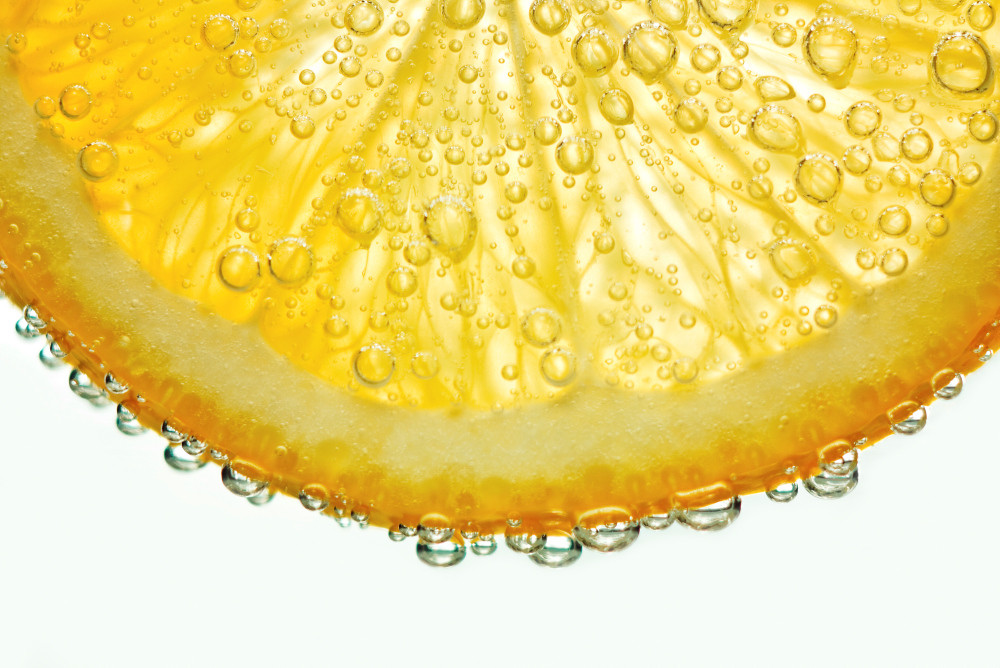 Zitronenscheibe mit perlender Flüssigkeit
