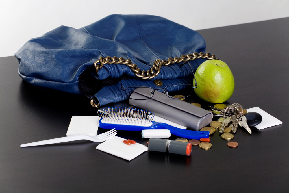 Blaue Handtasche und ausgekippter Inhalt Blaue Handtasche und ausgekippter Inhalt