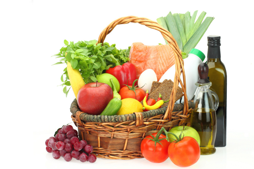 Korb mit den Zutaten der Mittelmeerkost: frisches Gemüse, Obst, Fisch, Olivenöl etc. 