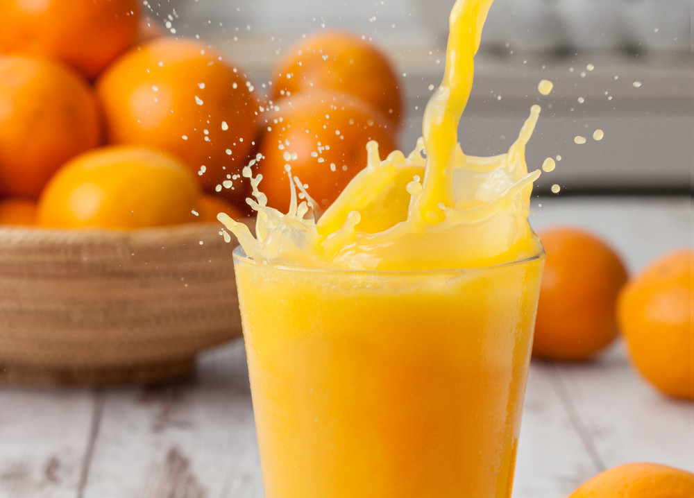 Orangensaft spritz aus einem Glas