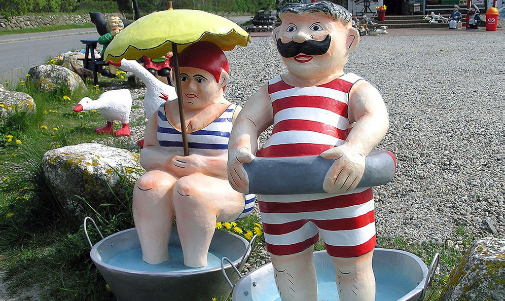Pappmaché-Paar im Badeanzug mit Sonnenschirm und Rettungsring