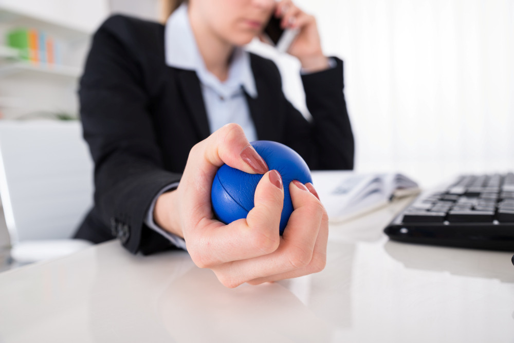 Geschäftsfrau telefoniert mit dem Handy und drückt Anti-Stress-Ball