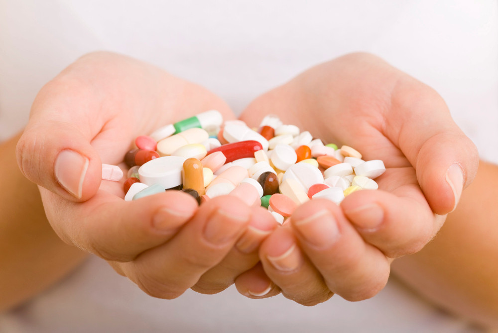 Bunte Tabletten und Kapseln in zwei Händen