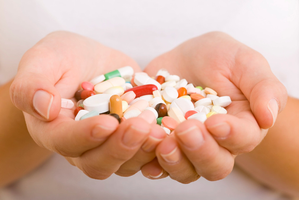 Bunte Tabletten und Kapseln in zwei Händen Bunte Tabletten und Kapseln in zwei Händen