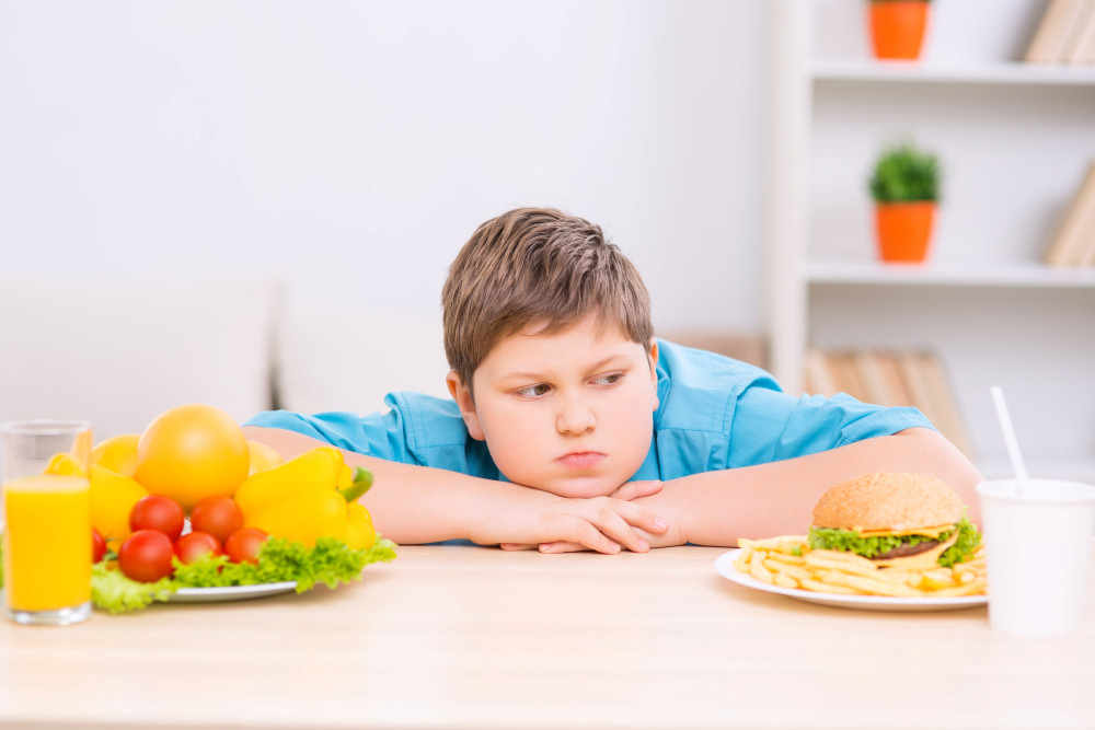 Übergewichtiger Junge hat die Wahl zwischen Bürger und Obst und Gemüse