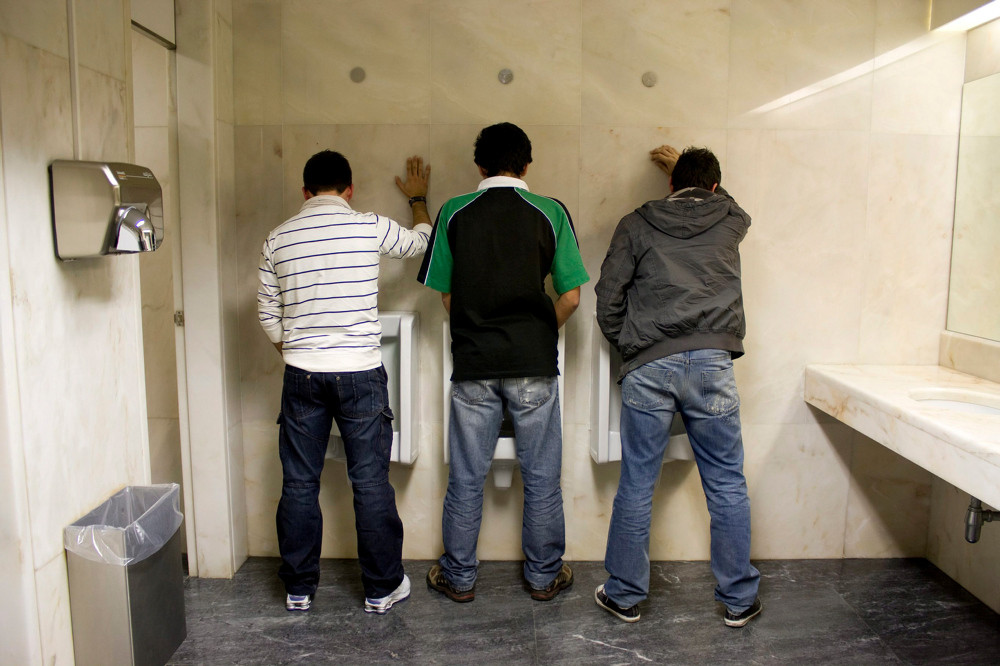 Drei Männer auf der Herrentoilette