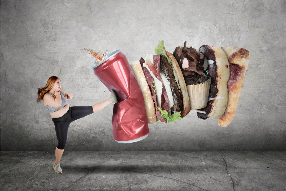 Übergewichtige Frau tritt gegen ungesundes Essen