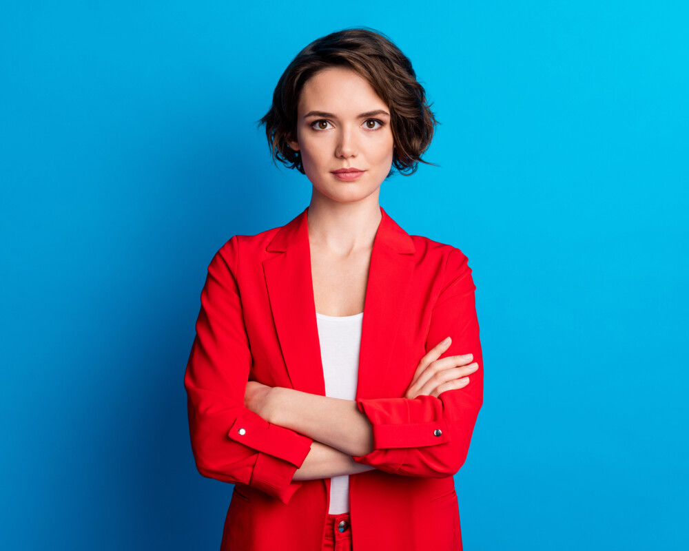 junge Frau mit verschränkten Armen, rotes Jacket junge Frau mit verschränkten Armen, rotes Jacket