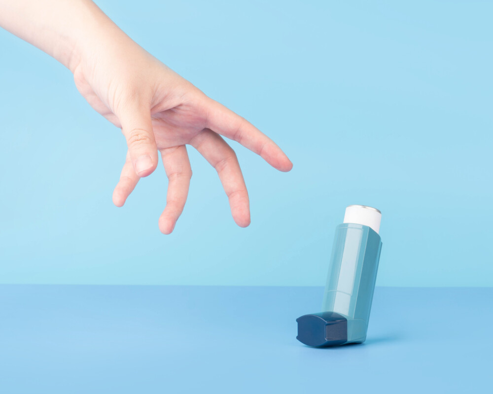 Hand greift nach Inhalator