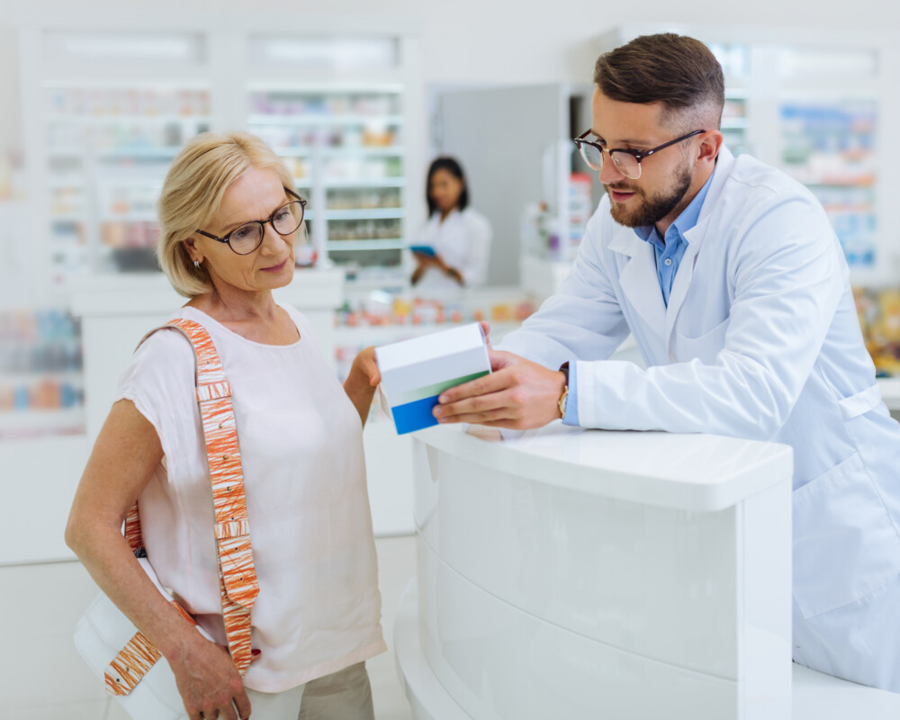 Apotheker/PTA erklärt einer älteren Kundin ein Arzneimittel