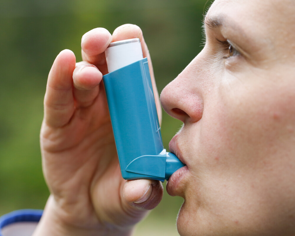 Frau inhaliert ein Asthmaspray