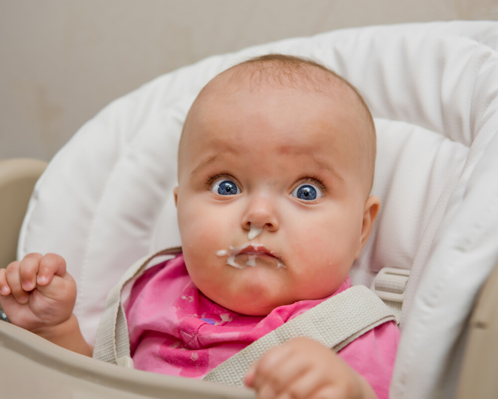 Baby mit breiverschmiertem Gesicht schaut in die Kamera. Baby mit breiverschmiertem Gesicht schaut in die Kamera.