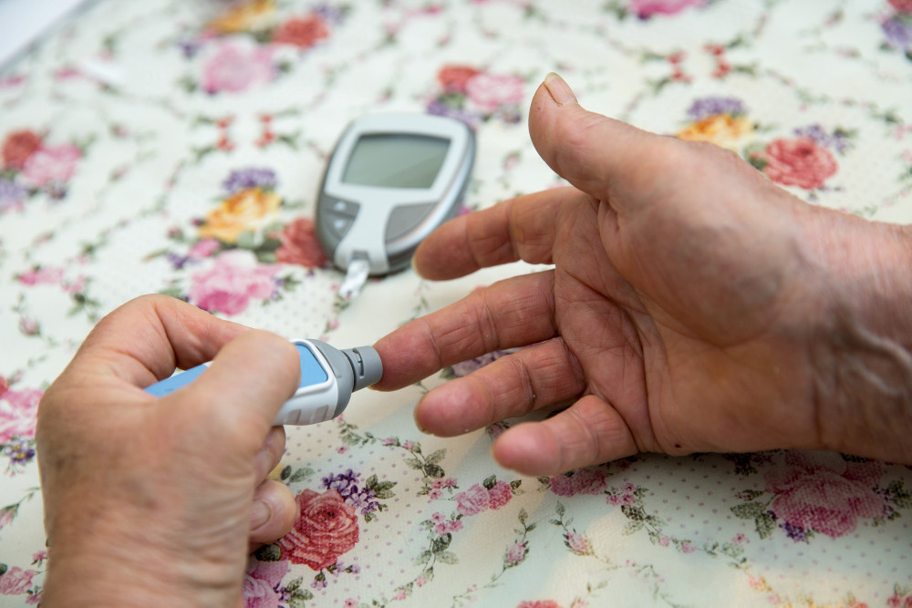 Seniorin überprüft mit einem Glukosemessgerät ihren Blutzuckerwert