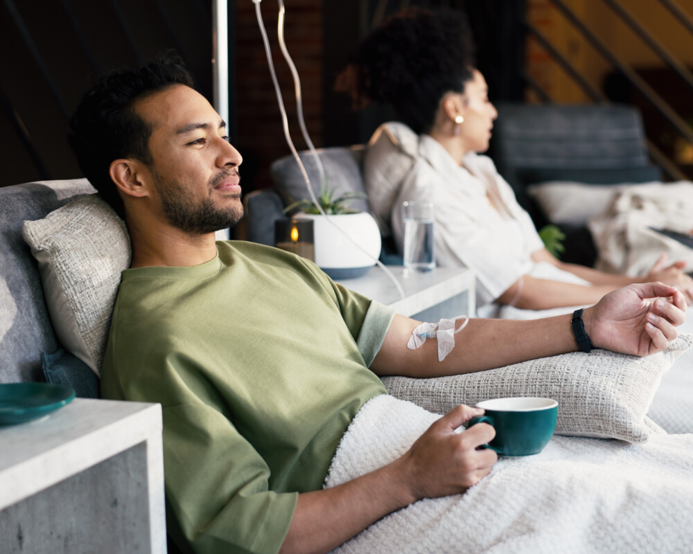 Personen beim Drip Spa, im Vordergrund ein Mann mit grünem Shirt und Teetasse in der Hand