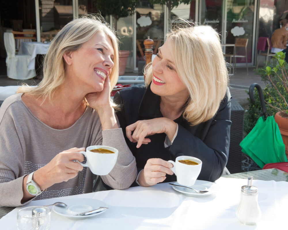 Zwei Frauen mit Kaffeetassen im Gespräch