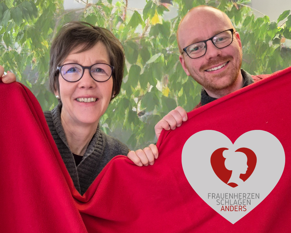 Stefanie Fastnacht und Christoph Niekamp mit roter Decke und Logo "Frauenherzen schlagen anders"