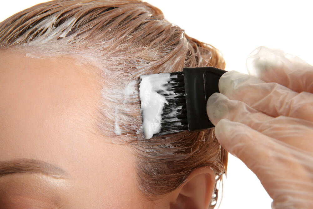 Junge Frau färbt sich die Haare selbst Junge Frau färbt sich die Haare selbst