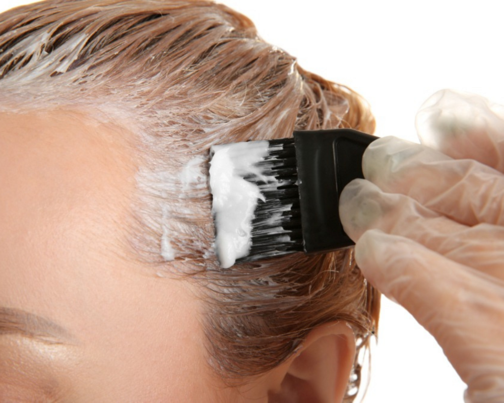 Junge Frau färbt sich die Haare selbst
