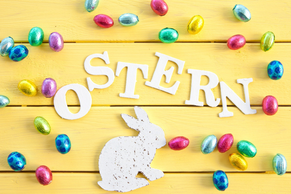 Schriftzug Ostern umgeben von bunten Schokoladenostereiern