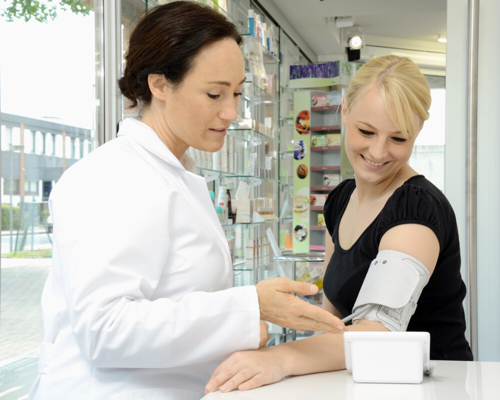 PTA misst Kundin den Blutdruck in der Apotheke.