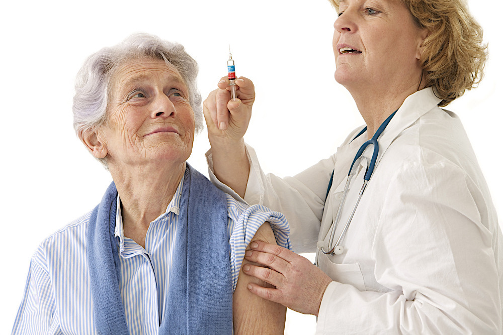 Ärztin zieht Spritze auf, um Seniorin zu impfen