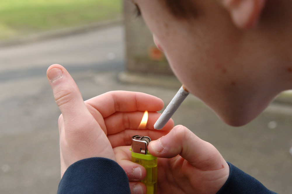 Jugendlicher zündet sich mit Feuerzeug eine Zigarette an