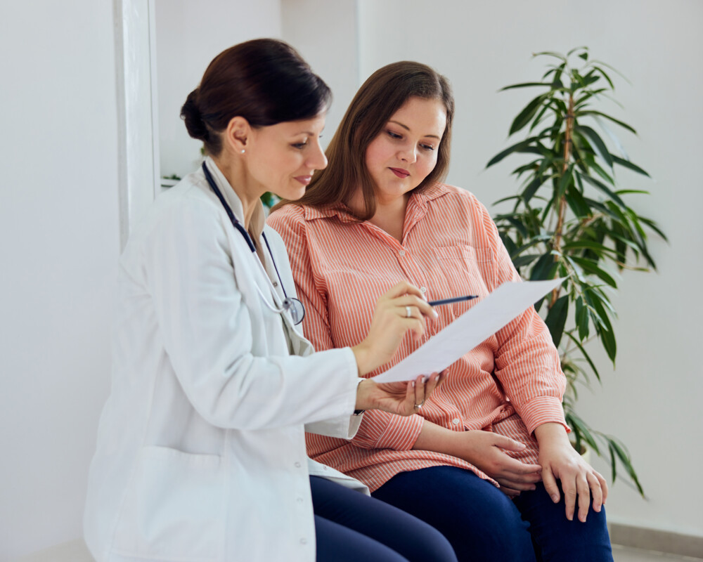 Ärztin erklärt übergewichtiger Patientin den Therapieplan Ärztin erklärt übergewichtiger Patientin den Therapieplan
