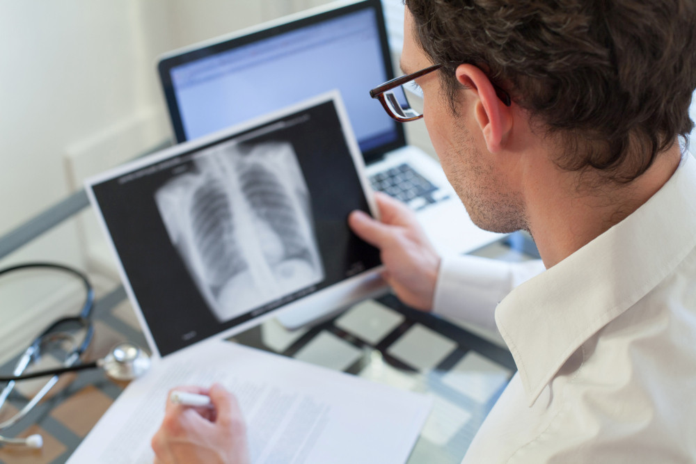 Arzt sieht sich Röntgenbild einer Lunge an