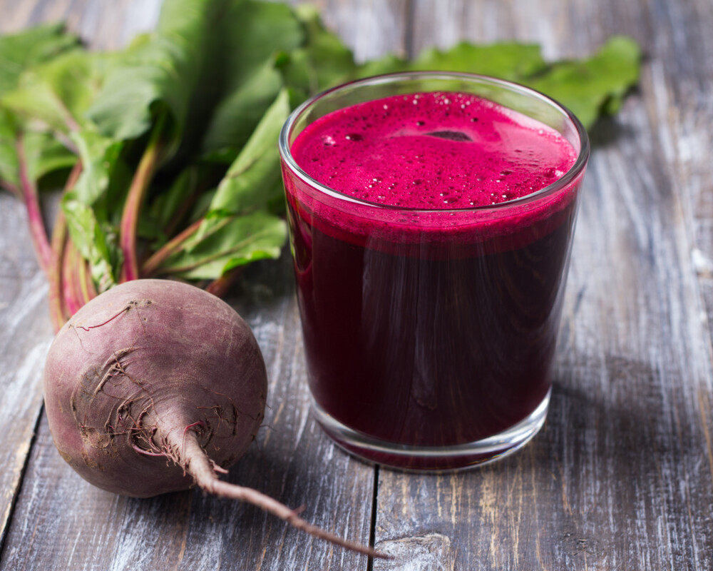 Rote Bete als Rüber mit Blattgrün und in einem Glas als Saft.