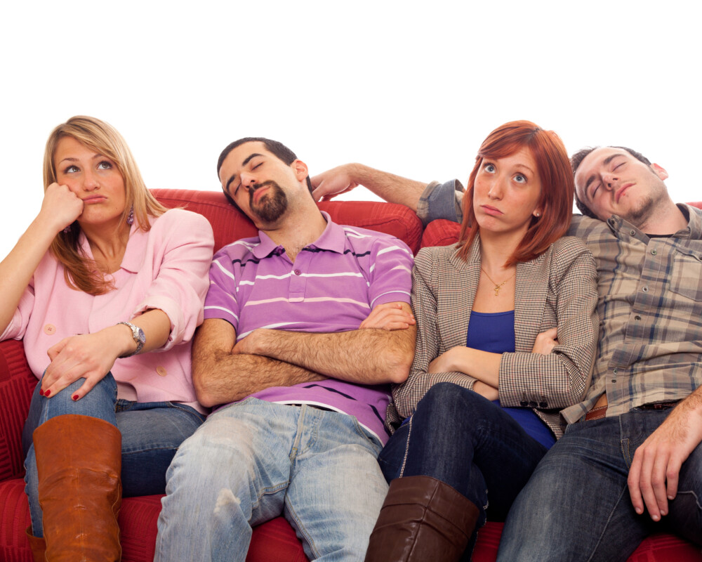 Gruppe von Männern und Frauen auf dem Sofa, teils wach, teils schlafend