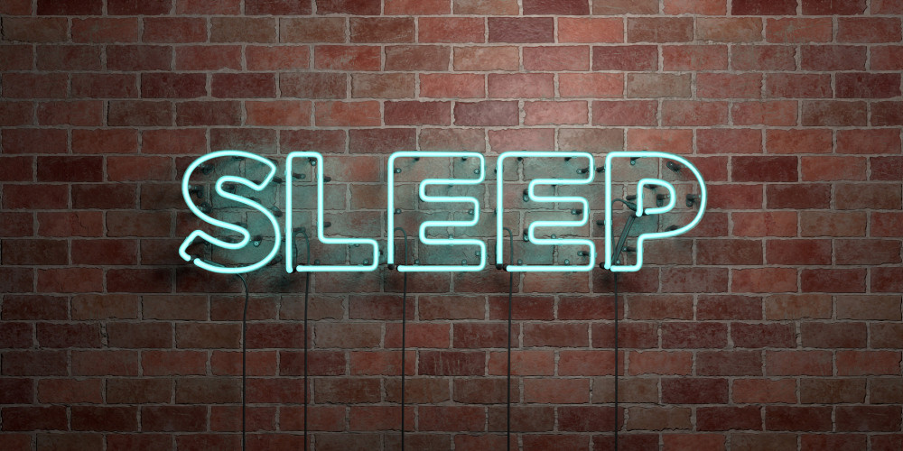 Leuchtendes Wort „Sleep“ auf Backsteinmauer