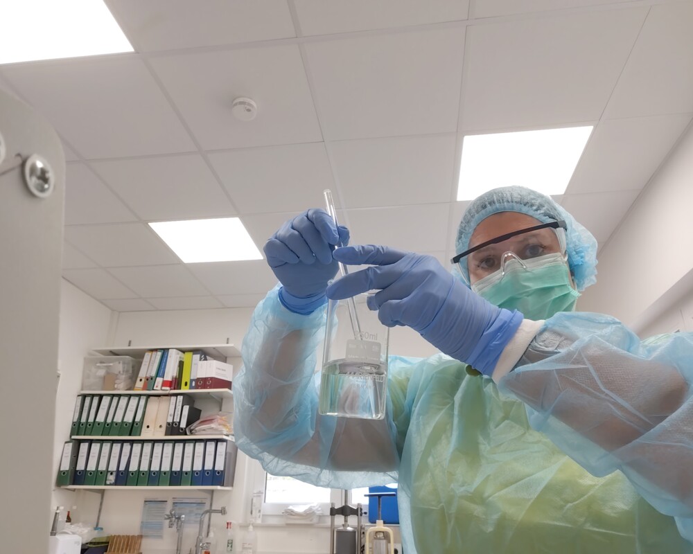 Sarah Siegler mischt die Insulinlsöung mit isotonischer Kochsalzlösung in einem Becherglas.