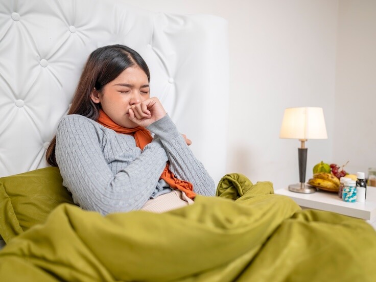 Frau mit Erkältung im Bett