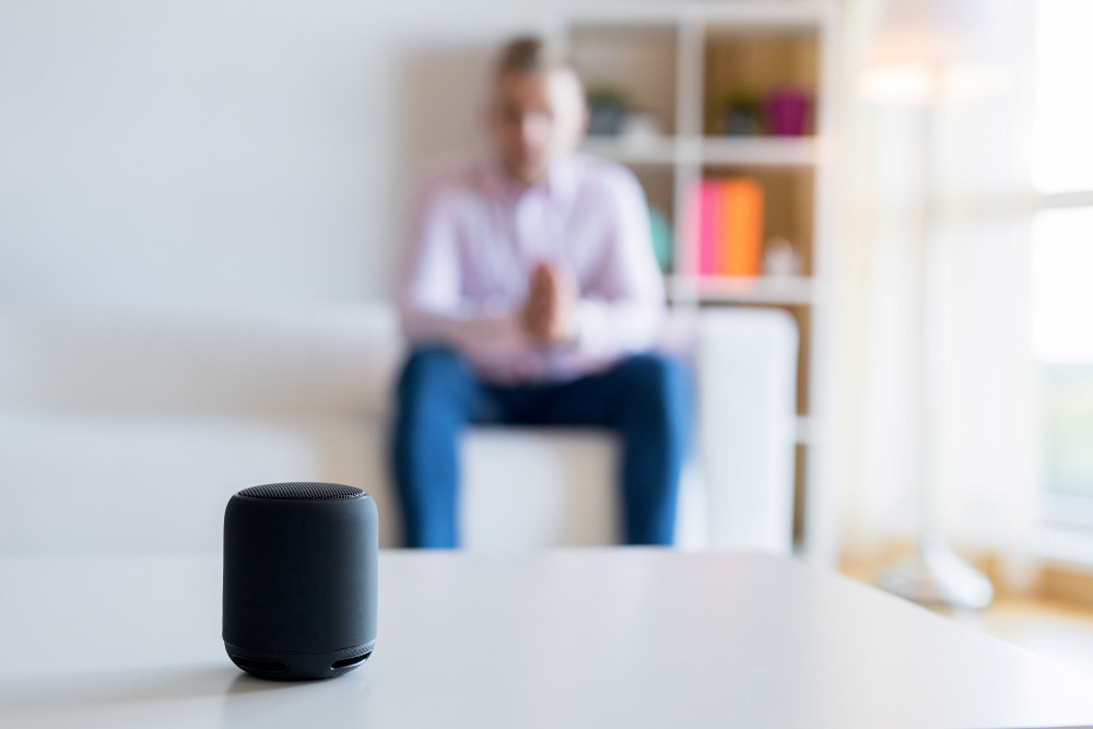 Mann unscharf im Hintergrund spricht mit smart speaker