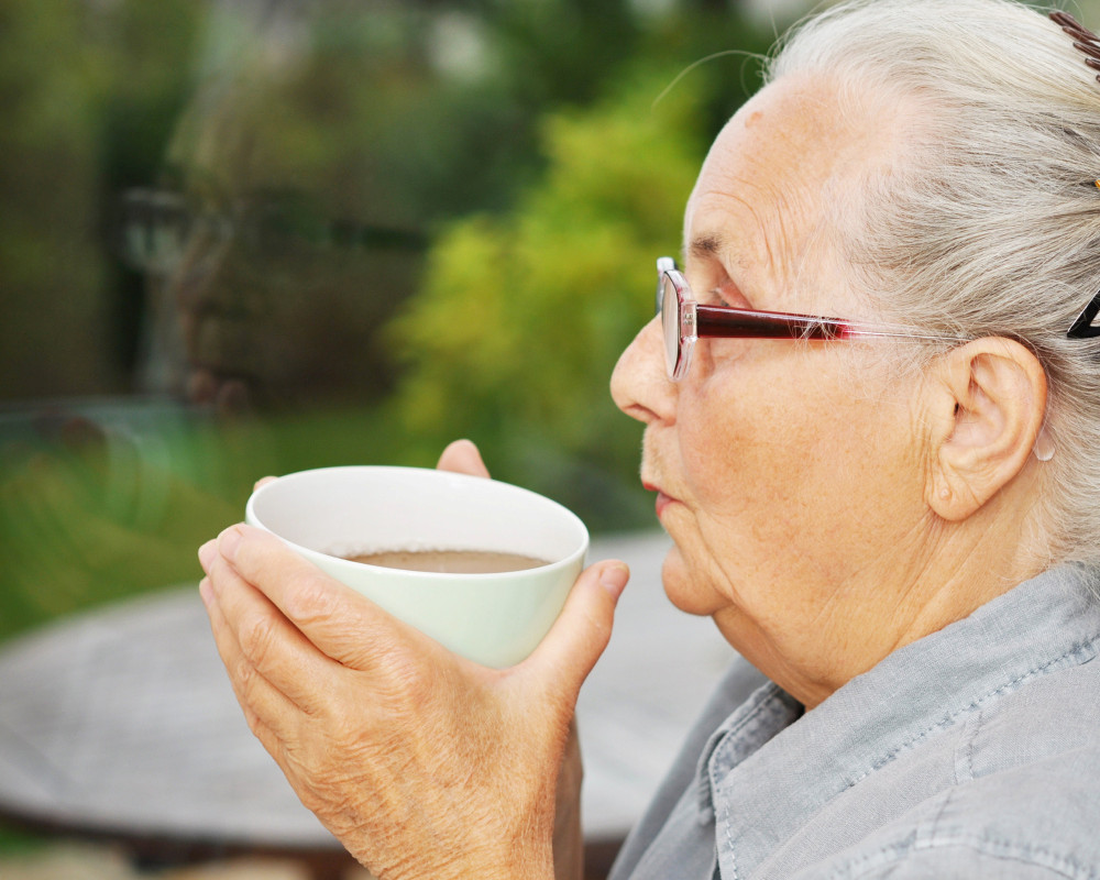 ältere Frau mit Teetasse in der Hand