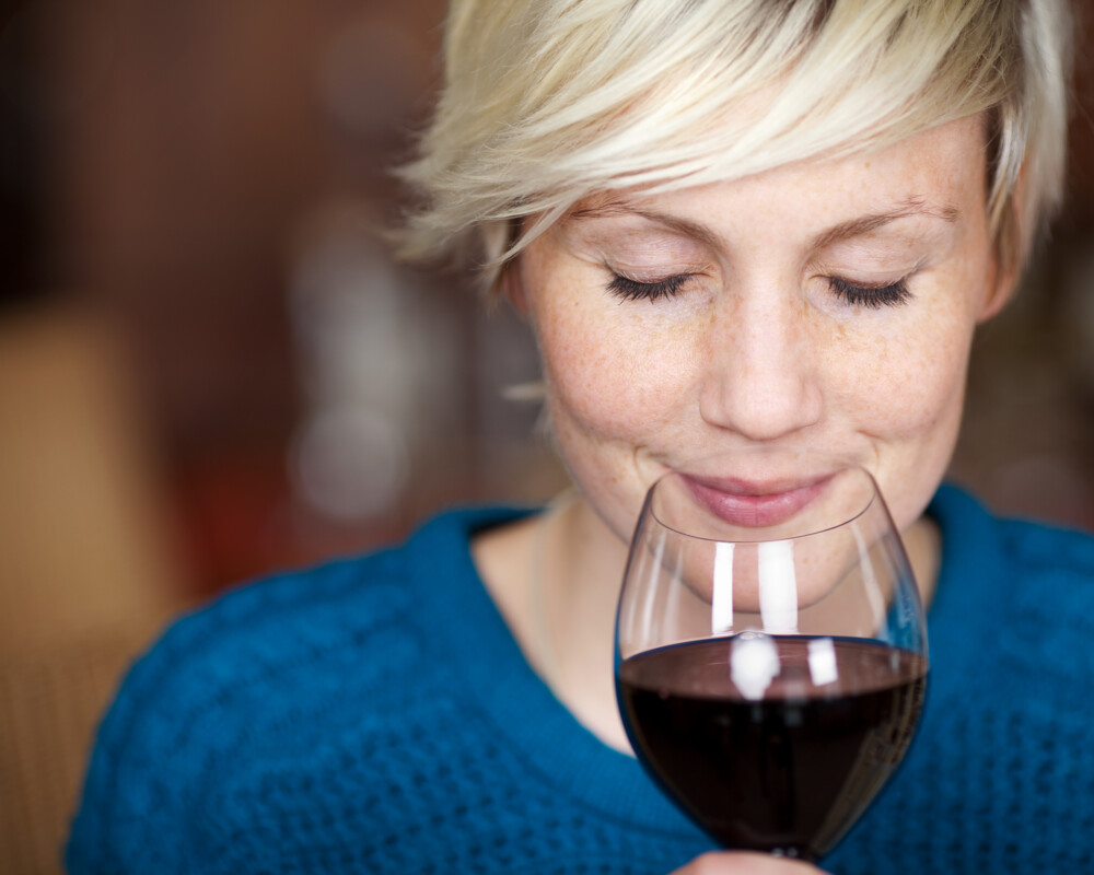 Lächelnde Frau genießt Rotwein