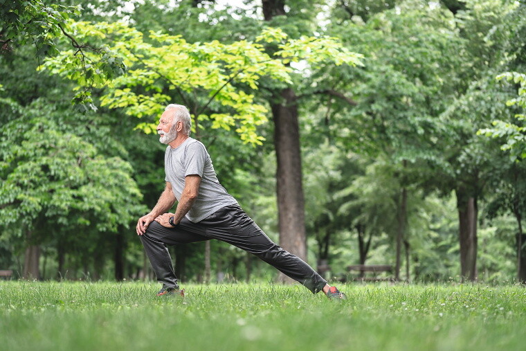 Älterer Mann macht Sport im Park.