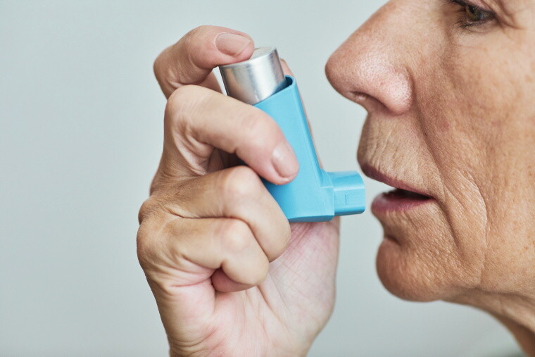 Frau mit Asthmaspray